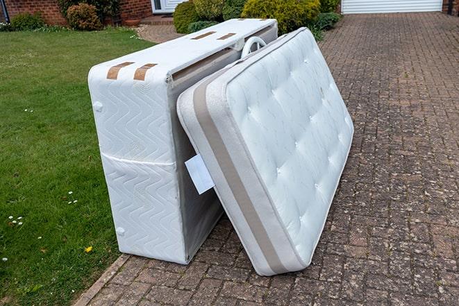 discarded mattresses being loaded onto a recycling truck